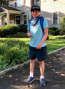 boy standing outside his house