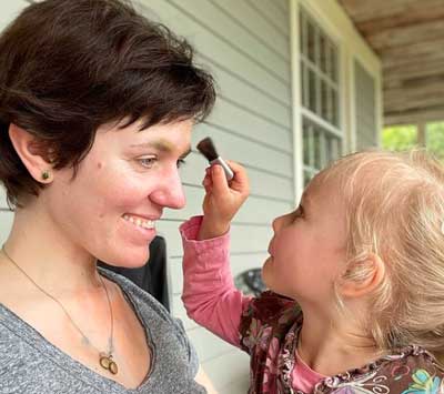 daughter applying make up brush to woman