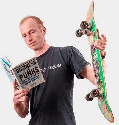 man holding a book and a skateboard